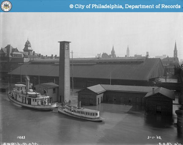 exterior of B&O train station during historic 1902 flood, boats float above the rail yard